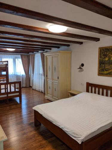 a bedroom with a bed and a wooden floor at Dorul Pescarului in Curtea de Argeş