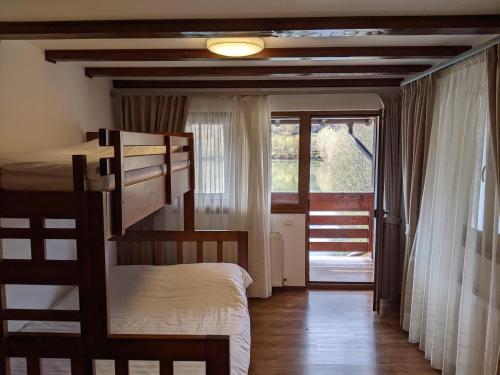 a room with two bunk beds and a window at Dorul Pescarului in Curtea de Argeş