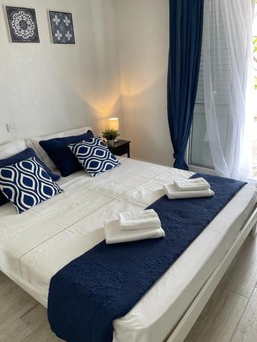 a large bed with blue and white pillows on it at Vila Kata in Zubovići
