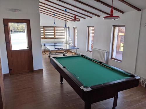 a pool table in a room with two tables at Dorul Pescarului in Curtea de Argeş