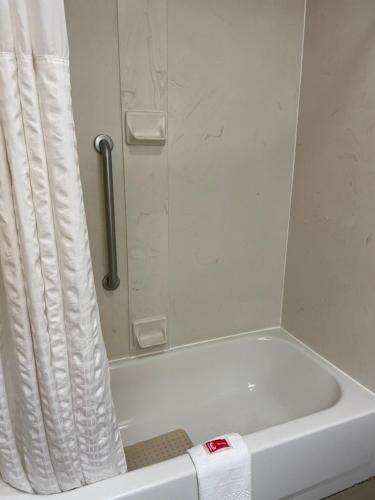 a white bath tub with a shower curtain in a bathroom at Econo Lodge Newport West in Newport