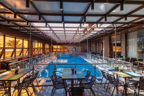 a large swimming pool with tables and chairs in a building at فندق ماس الوجه in Al Wajh