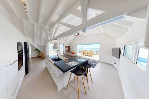 a kitchen with white cabinets and a black counter top at Walee Beach Penthouse by the sea, 2 bedrooms, pool in Saint Martin