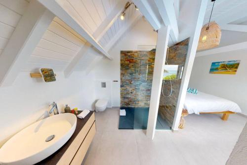 ein Bad mit einer Badewanne und ein Schlafzimmer in der Unterkunft Walee Beach Penthouse by the sea, 2 bedrooms, pool in Saint Martin