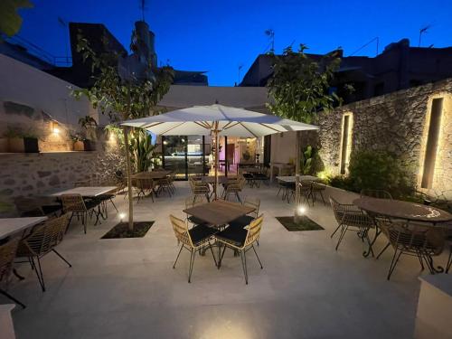 a patio with tables and chairs and umbrellas at night at Petit Hotel C'an Mel in Caʼs Concos