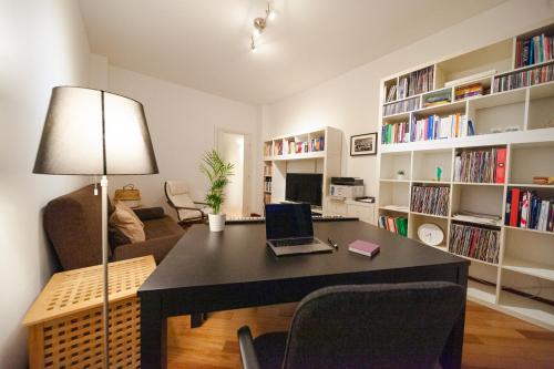 a living room with a desk with a laptop on it at Sebino Guest House in Milan