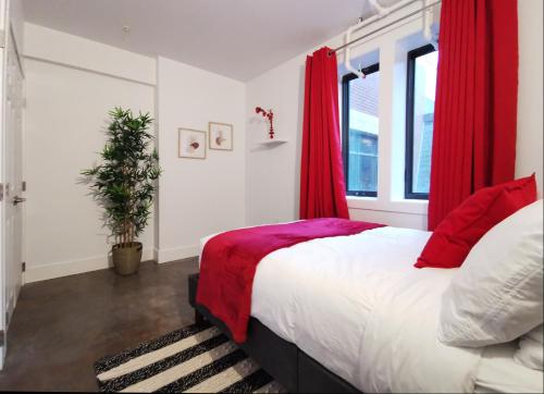 a bedroom with a large bed with red curtains at Cameo Hotel and Suites in Halifax