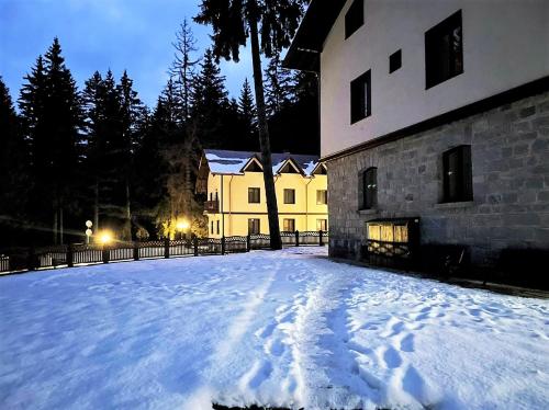 a snow covered yard in front of a building at Комплекс Орлово гнездо in Beli Iskar