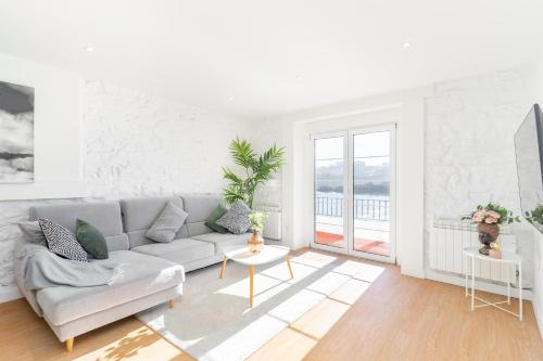 a white living room with a couch and a table at LA CASA DEL RELOJ in Luanco