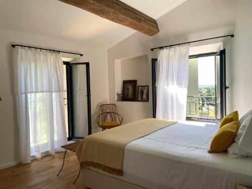 une chambre avec un lit et une grande fenêtre dans l'établissement Le Mas Angelou, à Maussane-les-Alpilles