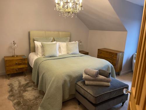 a bedroom with a large bed and a chandelier at River View in Dumfries