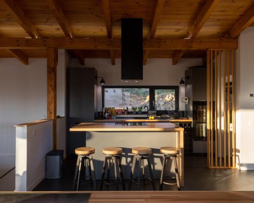 una cocina con techos de madera y taburetes de bar en Mountain Lodge, en Râșnov