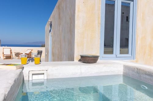 a swimming pool in front of a house with a patio at Oia's Cellars in Oia