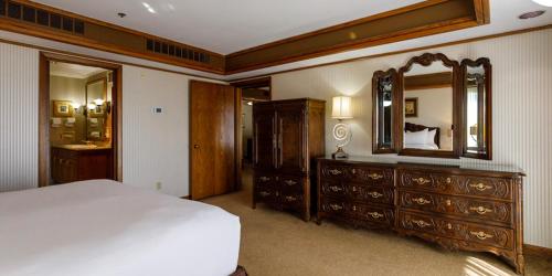 a bedroom with a bed and a dresser and a mirror at Maverick Hotel and Casino by Red Lion Hotels in Elko