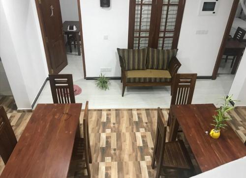 a living room with two wooden tables and a couch at Sunnyplace Guest Mirissa in Mirissa