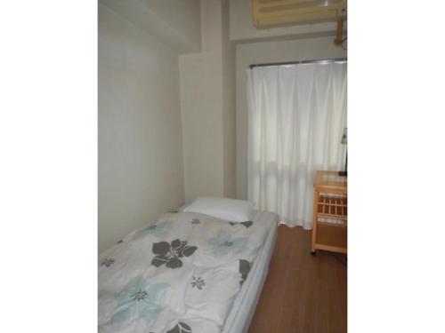a small bedroom with a bed and a window at Hostel Zen - Vacation STAY 91867v in Yokohama