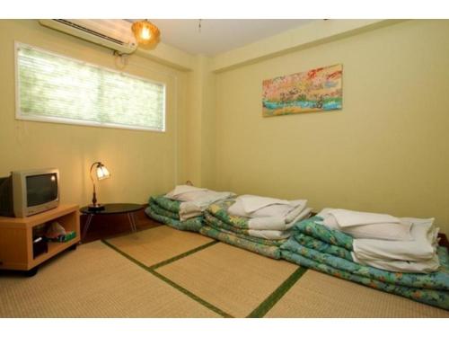 a living room with two beds and a television at Hostel Zen - Vacation STAY 91863v in Yokohama
