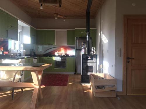 cocina con armarios verdes y suelo de madera en VILLA ECRİN, 