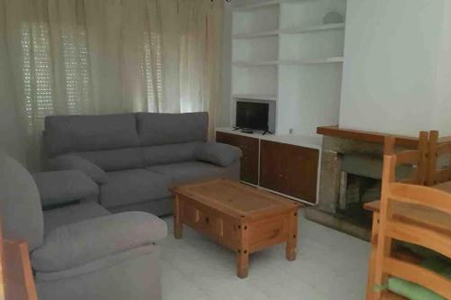 a living room with a couch and a coffee table at Adosado Dr Fleming 12 in Poyales del Hoyo