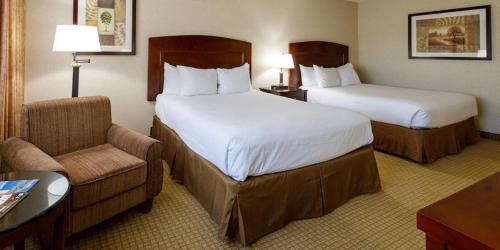 a hotel room with two beds and a chair at Maverick Hotel and Casino by Red Lion Hotels in Elko