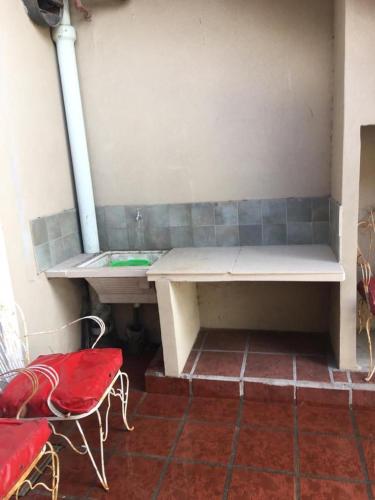 un banco en una habitación con mesa y sillas en Casa zona playa Necochea en Necochea