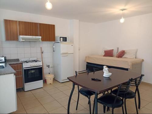 een kleine keuken met een tafel en een bed bij Apartamentos Santa Rosa PB 1 in Cordoba