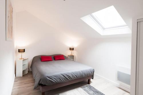 une chambre avec un lit avec deux oreillers rouges dessus dans l'établissement Le Solstice - Apt 60m2 1ch-4pers - Appart Hotel Poitiers, à Poitiers