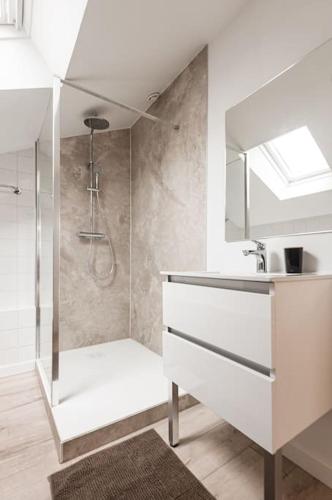 une salle de bain blanche avec une douche et un lavabo dans l'établissement Le Solstice - Apt 60m2 1ch-4pers - Appart Hotel Poitiers, à Poitiers