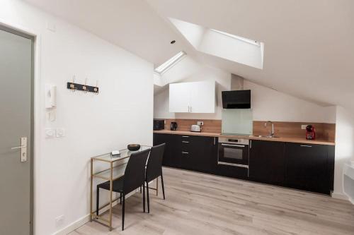 une cuisine avec une table et des chaises dans une pièce dans l'établissement Le Solstice - Apt 60m2 1ch-4pers - Appart Hotel Poitiers, à Poitiers