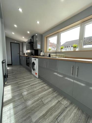 a large kitchen with a washer and dryer in it at Newly refurbished 3 bedroom/2bathroom entire house in Lincoln