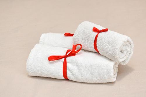 una pila di asciugamani con fiocchi rossi sopra di Olimpia Residence a Caserta