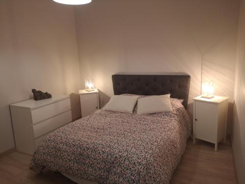 a bedroom with a bed with two lights on two night stands at Appartement 2 pièces avec terrasse proche mer et commerces in Ouistreham