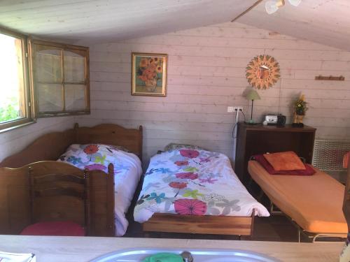 Habitación pequeña con 2 camas y mesa. en Duccio Cabana Hébergements Insolites, en Potelle