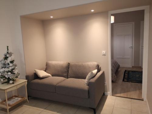 a living room with a couch and a christmas tree at Appartement 2 pièces avec terrasse proche mer et commerces in Ouistreham