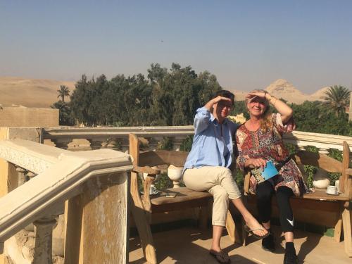 three people sitting on a bench in the desert at Sakkara pyramid inn hotel in Cairo