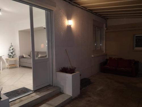 an open door to a living room with a couch at Appartement 2 pièces avec terrasse proche mer et commerces in Ouistreham