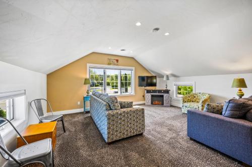 a living room with two couches and a fireplace at Julie's Park Cafe & Motel in Fish Creek