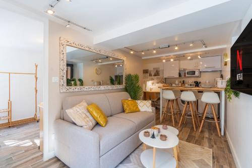 a living room with a couch and a kitchen at Le Bohème - Spa/Netflix/Wifi Fibre - Séjour Lozère in Mende