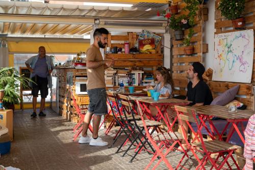 a man standing at a table in a restaurant at Aguere Nest Hostel in Las Lagunas