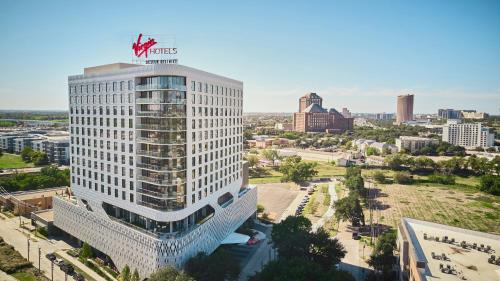 ein hohes weißes Gebäude mit einem amerikanischen Schild oben drauf in der Unterkunft Virgin Hotels Dallas in Dallas