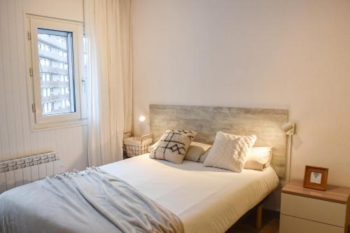 una camera da letto con un letto con lenzuola bianche e una finestra di ESTUDIO AVET - Perfecta ubicación a Pas de la Casa