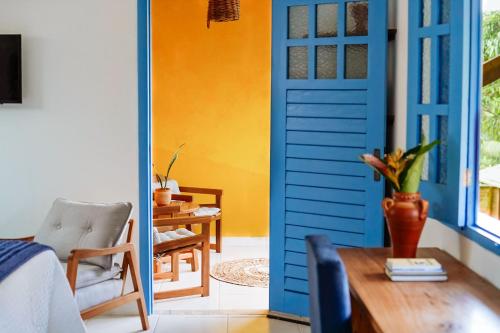 Habitación con puerta azul y mesa en Pousada Sabina, en Barra Grande