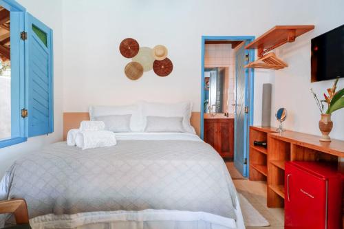 a bedroom with a white bed and a tv at Pousada Sabina in Barra Grande
