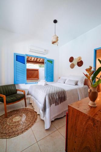 a bedroom with a bed and a chair and a window at Pousada Sabina in Barra Grande