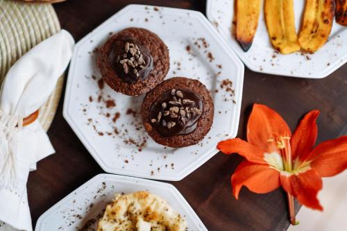 a table with two white plates with chocolate cookies and a flower at Pousada Sabina in Barra Grande