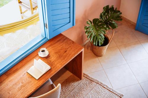 a table in a room with a potted plant at Pousada Sabina in Barra Grande