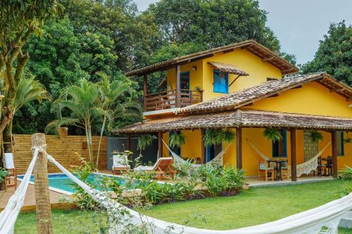a house with a hammock in front of it at Pousada Sabina in Barra Grande