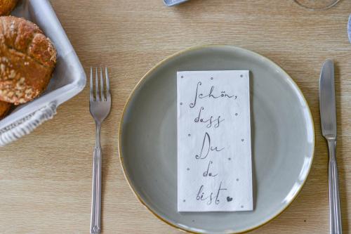 a plate with a napkin on it with a fork and knife at Gästehaus Alpenruh in Fischen
