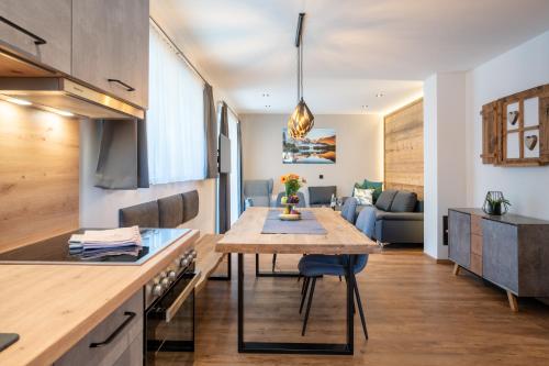 cocina y sala de estar con mesa y sofá en Apartment Waldherz en Wald im Pinzgau