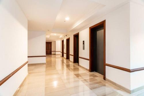 an empty hallway with white walls and wooden doors at Luxurious 2BDR condo located in Prestigious Tower. in Santo Domingo